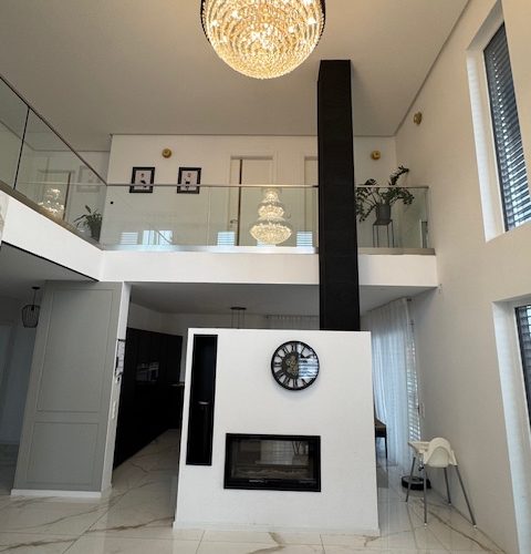 Blick zum Kamin mit dahinterleigender Küche